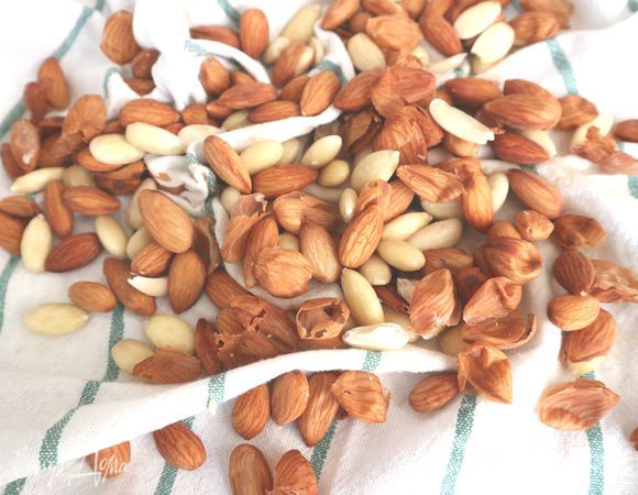 Для приготовления пирога потребуется крошка миндаля, можно воспользоваться готовой. Если ее нет, миндаль на 3-4  минуты опустить в кипящую воду, затем слить воду через дуршлаг, ополоснуть холодной водой. Положить миндаль на одну часть полотенца, накрыть другой, снять шелуху, немного потерев миндаль в полотенце. 

