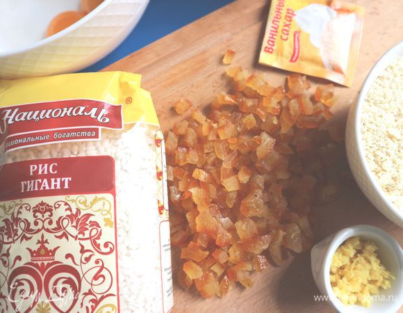 Цедру натереть на терке. Цукаты порезать. Миндаль измельчить с помощью блендера. Довести молоко до кипения, добавив сахарный песок и половину цедры.
Всыпать рис и соль (2 щепотки). Довести до кипения, огонь уменьшить до минимального и варить 25 минут, помешивая. Снять с огня, дать остыть в течение примерно 30-40 минут. Во время остывания надо так же перемешивать периодически.