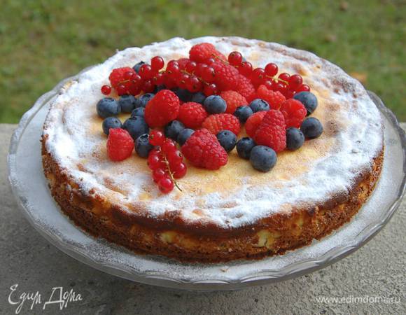 Творожник остудить, затем вынуть из формы, посыпать по краю сахарной пудрой, а середину украсить ягодами.
