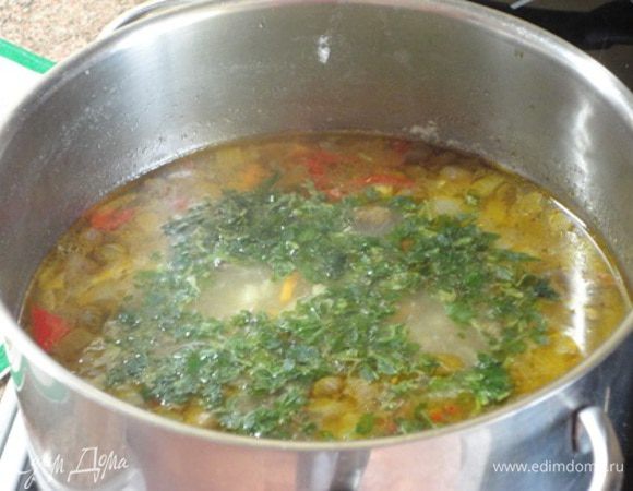 Овощи добавить к бульону. Сюда же выложить готовую перловку и варить при умеренном кипении 5 минут. Добавить каперсы, 1 лавровый лист, соль, любимые специи, довести до кипения и добавить зелень. Выключить нагрев и дать настояться супу 10 минут.