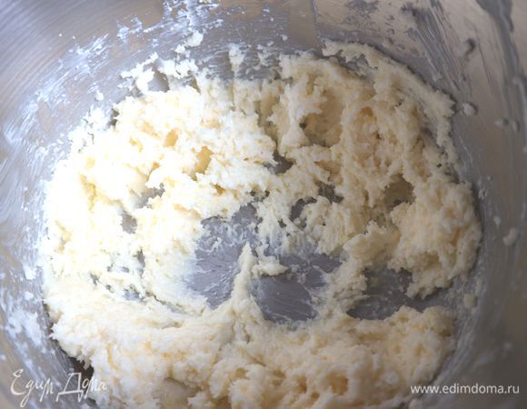 Духовку разогреть до 180°С. Взбить масло с сахаром до состояния светлого крема. Добавить цедру, перемешать.