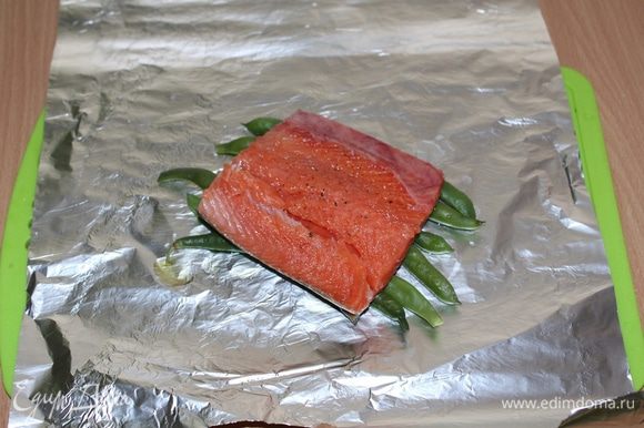 На фольгу выложить (отваренную 2-3 минуты) фасоль, сверху кусочек рыбы шкуркой вниз.
