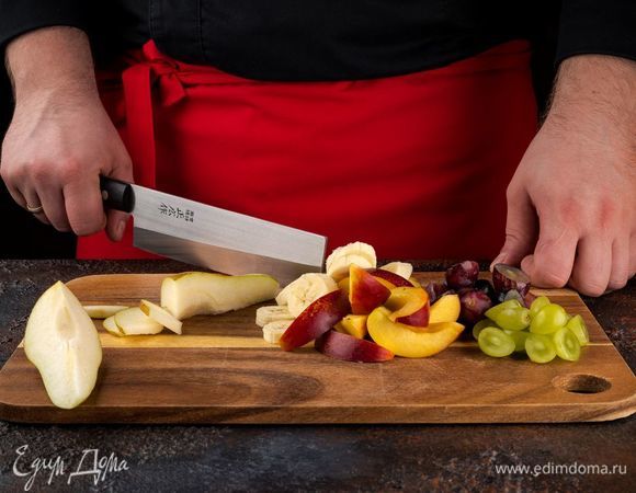 Нарежьте фрукты небольшими кусочками. Ягоды винограда разрежьте пополам и удалите косточки.