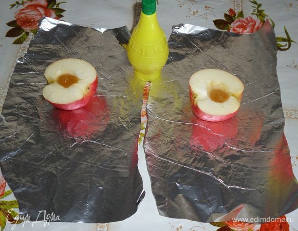 Яблоки промываем водой. Обсушиваем. Разрезаем на 2 части и удаляем сердцевину. Фольгу нарезаем на куски. На кусок фольги кладем половину яблока. В серединку яблока кладем 1/3 ч. л. меда.