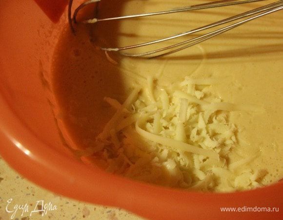 Далее добавить 1/2 стакана просеянной муки и сыр, натертый на крупной терке. Перемешать.
