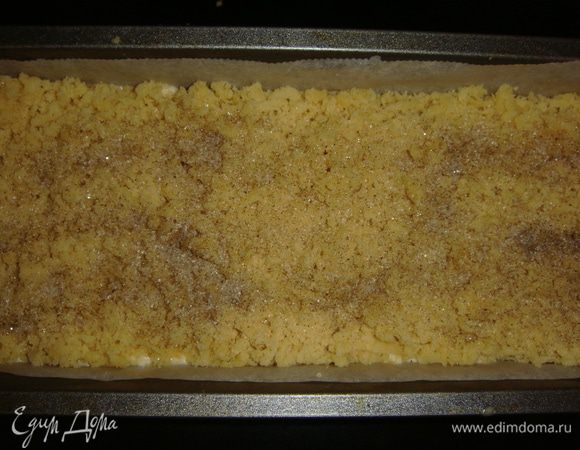 Сверху натереть замороженную часть теста и посыпать коричневым сахаром. Выпекать в разогретой до 180°С духовке 30 минут. 