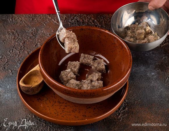 Приготовьте мясной студень, нарежьте кубиками и разложите в глубокие тарелки.