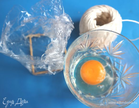 Кладем трафарет, приподнимаем края пищевой пленки, внизу по линии трафарета пленка должна примыкать полностью. Яйцо разбить в стакан, желток должен остаться целый. 