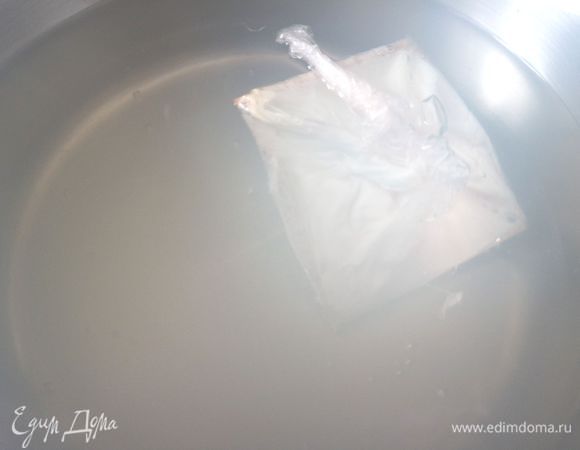 В закипевшую воду, которая едва кипит, добавить белый винный уксус. Рядом держите кастрюлю с холодной водой, в которую добавлена соль. Сделать в кипящей воде столовой ложкой воронку, выпустить яйцо в мешочек из пленки, который тут же поместить в воронку. Концы пленки тут же закрутятся, пленку можно отпустить. Если у вас яйцо не одно, а несколько, то надо выпускать в воду по 1 яйцу. 