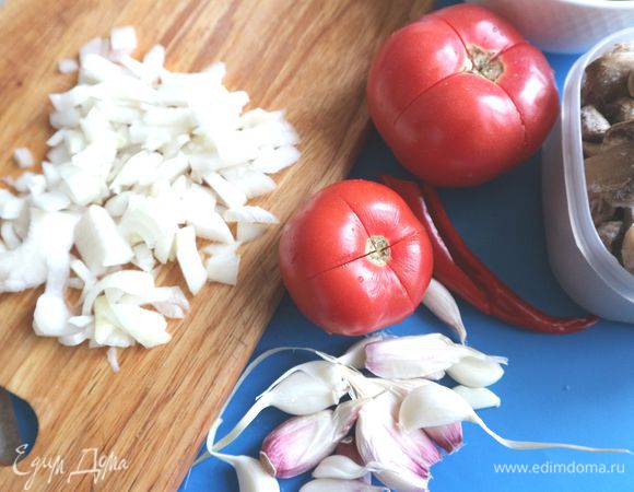 С чеснока снять только верхнюю шелуху. Лук порезать кубиками, помидоры надсечь крест-накрест. Перцы порезать на половинки, удалить семенную часть, завернуть в фольгу, запечь в духовке при 200°С 30 минут, вынуть из фольги, обдать холодной водой. Чеснок завернуть в фольгу, запечь в течение 20 минут, вынуть, очистить от шелухи.