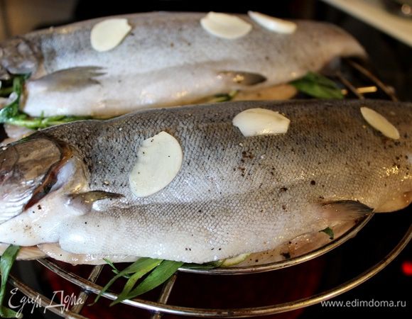 Форель переложите на решетку для гриля и запекайте в течение 30 минут на среднем жаре.