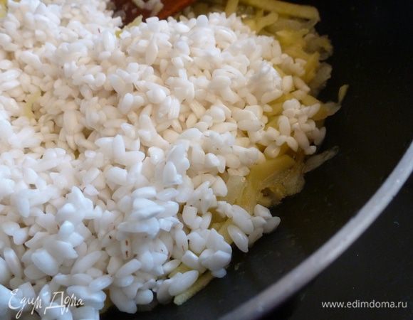 Рис ризотто от ТМ «Националь» промыть и замочить в воде на 15 минут. Выложить в сковороду к луку и яблоку.