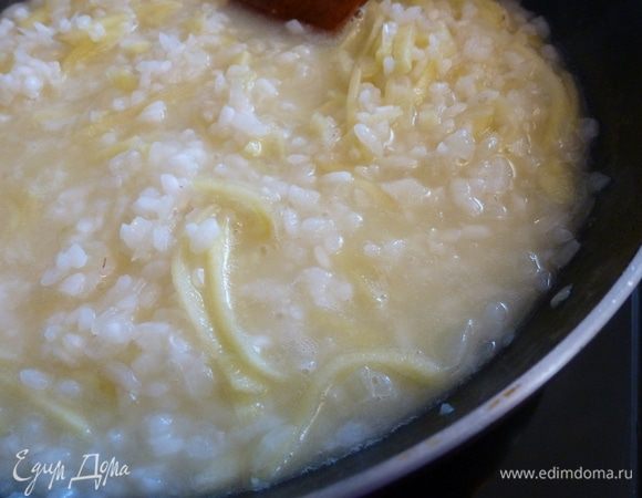 Куриный бульон заранее поставим на огонь и доведем до кипения, убавим огонь и держим его на плите слегка кипящим. 
Частями подливаем его в рис, дожидаясь пока бульон впитается.