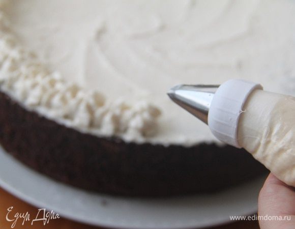 Украсить верх торта взбитыми сливками.