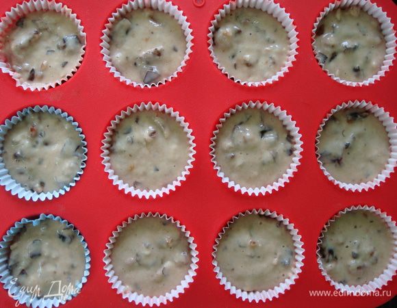 В силиконовые формочки для кексов вложить бумажные капсулы. Выложить в них тесто на 3/4 и поставить в разогретую до 180°С духовку на 25-30 минут. Готовность проверить зубочисткой.