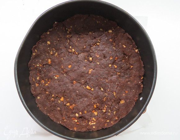 Через полчаса форму (20–22 см) проложить пергаментной бумагой, выложить тесто на дно формы для запекания. Бортики делать не надо.