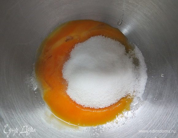 Готовим шоколадную начинку. Яйца делим на белки и желтки. Желтки кладем в миску, добавляем 80 г сахара и взбиваем около 10 минут до пышной, светлой массы.