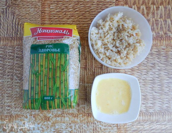 Если у вас есть уже готовый рис (понадобится 205 г), тогда переходите к следующему подпункту. Если нет, тогда сначала нужно сварить рис Здоровье ТМ «Националь». 1 стакан воды налить в кастрюлю, посолить и довести до кипения. Рис промыть, всыпать в кипящую воду, уменьшить огонь до слабого и варить под крышкой 25 мин. Затем уменьшить огонь до минимального и готовить еще 15 мин. Снять кастрюлю с огня и дать постоять еще 20 мин., чтобы рис впитал всю оставшуюся воду. Затем рис остудить. Духовку разогреть до 190°С. Рис приправить по вкусу перцем и солью (если необходимо). Добавить яйцо и хорошо перемешать. 
