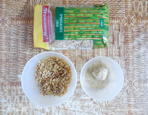 Духовку разогреть до 180°С. Орехи измельчить в крошку (самый удобный способ — сложить в пакет и постучать по ним скалкой). Подготовить 2 небольшие миски: в одну поместить орехи, в другую — белок. Теперь перейдем непосредственно к формированию трюфелей. Столовой ложкой набирать остывшее ризотто и влажными руками скатать шарики. Каждый шарик обмакнуть в белок, затем обвалять в ореховой крошке.  
Из указанного количества ингредиентов получается 16 трюфелей.