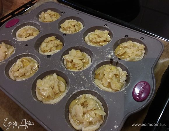 Выпекать 10 минут. За это время смешать миндальные лепестки с яблочным сиропом и через 10 минут распределить их по пирожным. Допекать еще 10-15 минут. 