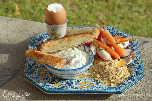 Подавать яйца со сметанной заправкой, ореховой крошкой, замаринованными овощами и хлебными палочками.