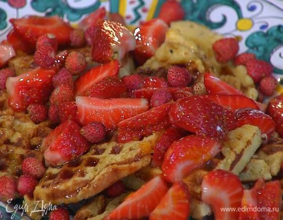 На готовые вафли выложить клубнику, полить кленовым сиропом и посыпать земляникой.