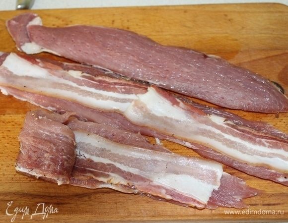 Кусочки мяса слегка отбить, выложить бекон и свернуть рулетиком.