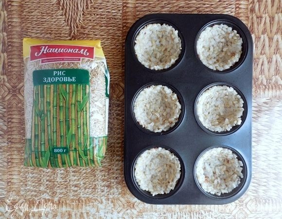 Формы для кексов (6 шт.) хорошо смазать растительным маслом (возможно, удобнее будет использовать силиконовые формочки). Поровну распределить рис между формочками и влажными руками прижать, формируя бортики и дно. Выпекать основы 20 мин., затем дать им остыть. 