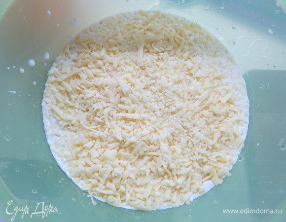 Готовим сливочно-сырную заправку. Сыр трем на средней терке и добавляем к сливкам. Перемешиваем.
