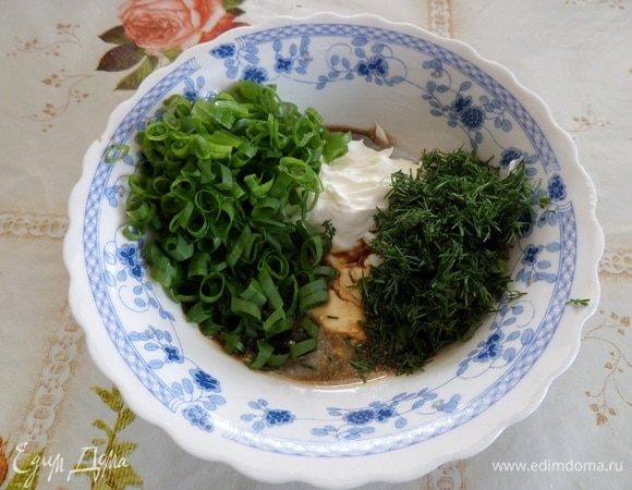 В чашку выкладываем сметану, соль, соевый соус и нарезанную зелень.