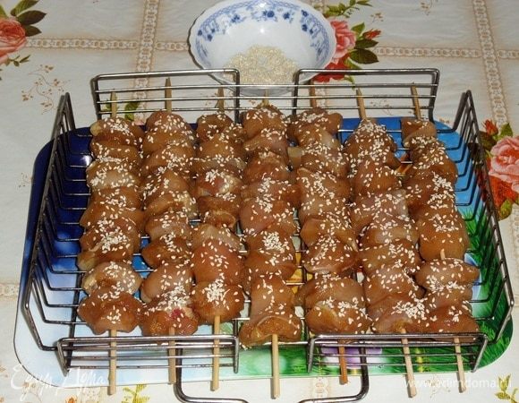 Посыпаем куриное мясо на шпажках кунжутом со всех сторон.