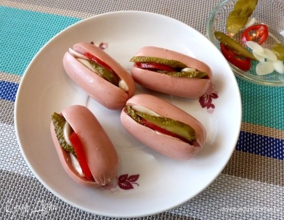 Сосиски надрежем с одной стороны. В прорез положим по кусочку чили, огурца и чеснока.