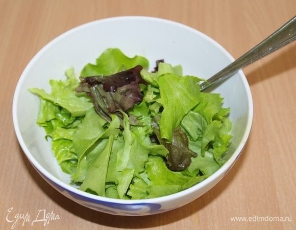 Листья салата порвать руками, полить частью заправки.