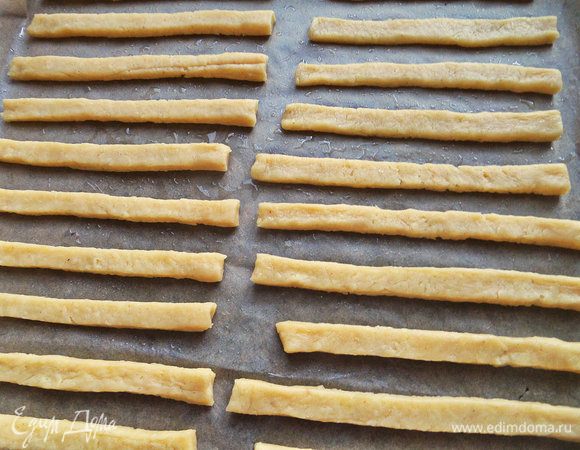 Противень застелить промасленным пергаментом и выложить партию полосочек.