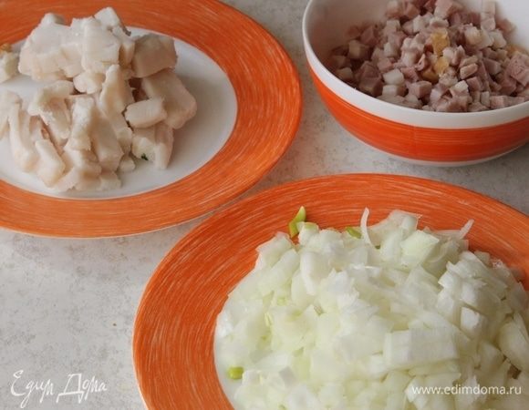 Нарежьте мелкими кубиками 2 головки лука, сало и бекон.