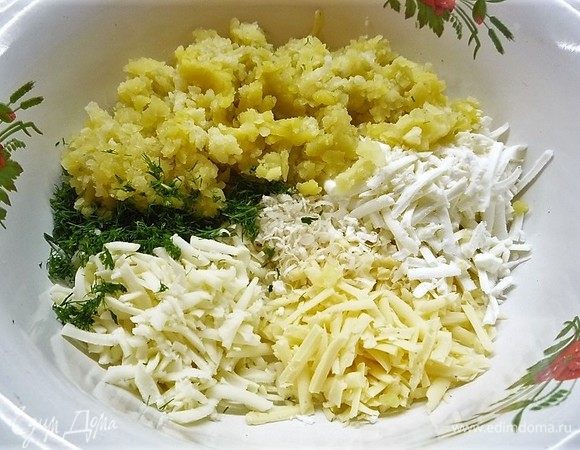 Картофель выкладываем в чашку, добавляем сыр, зелень, чеснок, солим и перчим по вкусу, все хорошо перемешиваем.