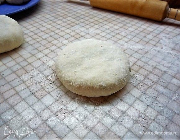 Переворачиваем начинку в тесте защипнутой стороной вниз и формируем тонкую лепешку. Сначала расплющиваем немного ладонью, затем осторожно растягиваем пальцами.