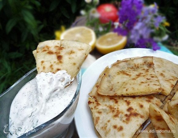 Подаем хычины со сметанно-чесночным соусом. Для соуса смешиваем йогурт с мелко нарезанным укропом, добавляем измельченный чеснок, лимонный сок, солим и перчим по вкусу.