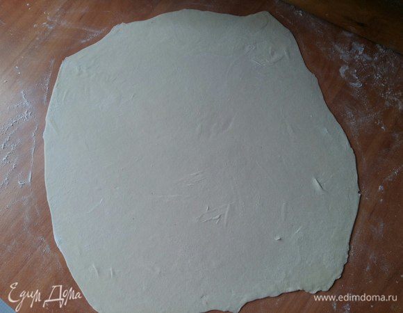 Берем 1 часть теста и раскатываем в тонкую лепешку, периодически переворачивая ее и все время подсыпая стол мукой. Как только раскатали, еще раз припылим мукой с двух сторон и уберем в сторону лепешку подсохнуть минут на 15. Это обязательно нужно делать! Иначе потом при сворачивании она слипнется и пахлава может не получиться.