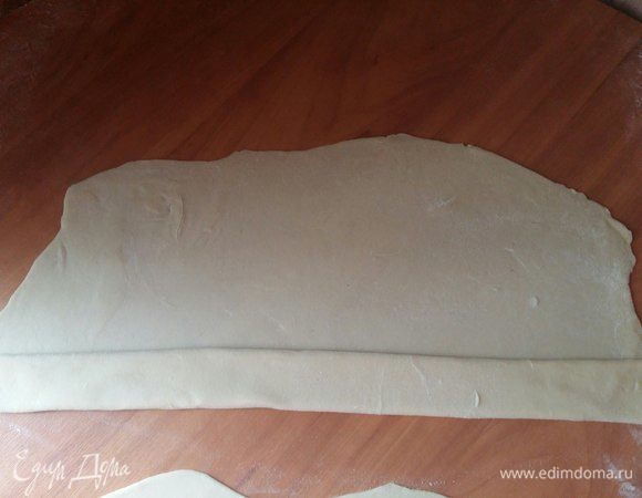 Прошло время, сворачиваем лепешку шириной примерно 4 см. Как только свернули до середины, смочим края лепешки водой и свернем до конца.