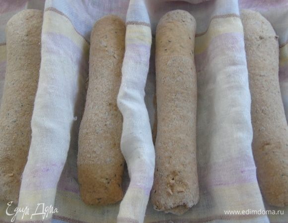 Делим тесто на 4 части, каждую раскатываем и заворачиваем рулетом. У меня нет специальной формы для багетов, поэтому я сформировала ячейки полотенцем. Накрываем и даем подойти минут 20-25. 