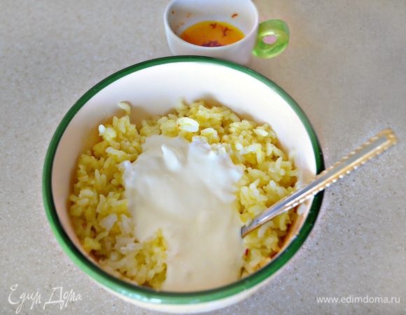 Часть риса смешать с йогуртом и небольшим количеством шафранного раствора. Риса должно быть достаточно, чтобы покрыть слоем примерно в полсантиметра дно посуды, в которой вы будете его готовить.
