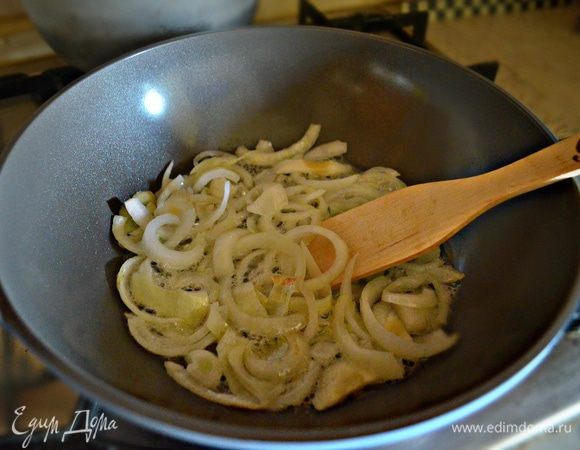 Пока готовится рис, поджарить лук, нарезанный полукольцами, на растительном масле до золотистого цвета.