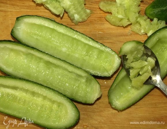 Огурцы разрезать на две части и вынуть мякоть.