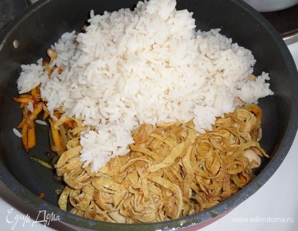 Добавляем к мясу и овощам отварной рис, нарезанные яичные блинчики, оставшийся соевый соус и красный молотый перец (по вкусу).