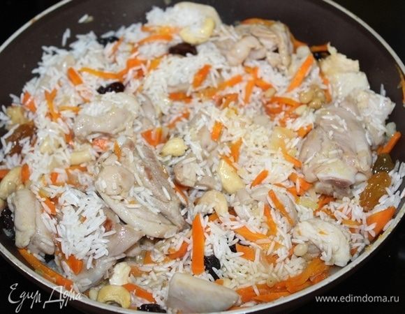 Затем добавляем рис, перемешиваем. В отдельной сухой сковороде слегка прокалить орешки и добавить к рису. Сюда же добавляем изюм.