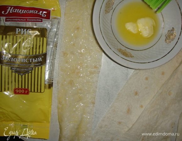 Растопить 50 г сливочного масла и смазать казан. Лаваш нарезать средними полосками. Каждую полоску смазать с одной стороны сливочным маслом.