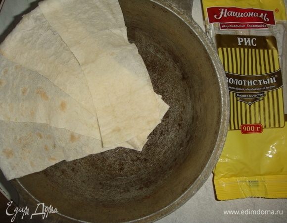 Выложить полоски лаваша смазанной стороной к казану, внахлест, оставляя концы лаваша свисать с казана.