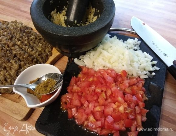 Баклажаны запечь, снять кожицу, порубить мелко крупным ножом или секачкой. Помню, бабушка раньше баклажаны для икры рубила вот этой самой секачкой, теперь на помощь пришли современные блендеры. Лук и помидоры мелко нарезать. Подготовить все специи. Имбирь растереть с чесноком в кашицу. 1 порцию зиры оставить отдельно от остальных специй. 