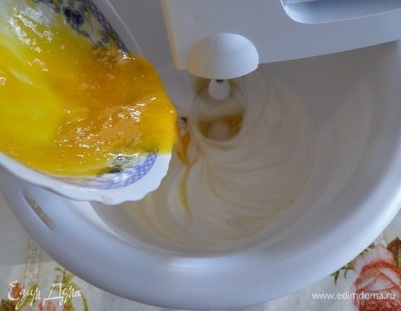 В чашку к взбивающимся белкам добавляем желтки.